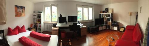 a living room with a couch and a desk with a computer at B&B Tomsi in Pratteln