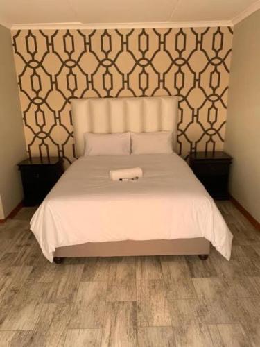 a bedroom with a white bed with a large headboard at Grandview adventure and guesthouse in East London