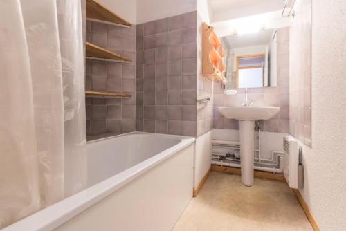 une salle de bain avec une baignoire et un lavabo dans l'établissement Résidence Le Tetras Lyre - Au pied du télécabine magnifique appartement MAE-7651, à Aime La Plagne
