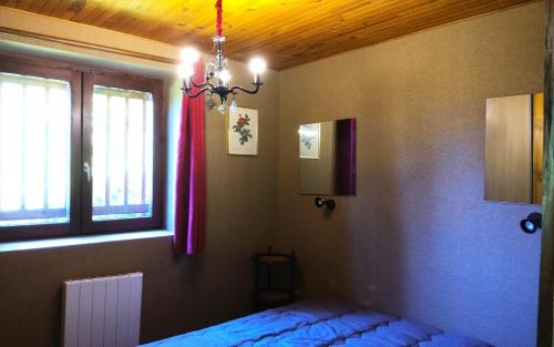 a bedroom with a bed and a chandelier at Résidence Deux Tetes - Très agréable 2 pièces dans un quartier calme à 50 mètres des pistes MAE-4491 in Arc 1600