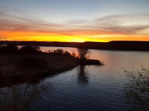 a sunset over a body of water with the sun setting at Osiris Guest House in Abu Simbel