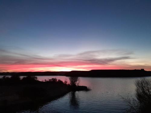 a sunset over a body of water at Osiris Guest House in Abu Simbel