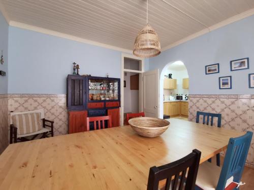 a dining room with a wooden table and chairs at Casa do Terraço by Madrabica in Atouguia da Baleia
