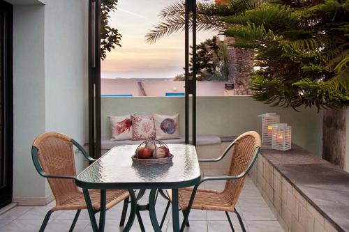 - une table et des chaises sur une terrasse avec vue sur l'océan dans l'établissement Minos Apartments & Studios, à Siteía