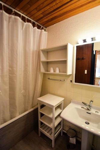 une salle de bain avec un lavabo et un rideau de douche dans l'établissement Résidence Le Makalu - Studio divisible 4/5 pers - LE MAKALU - PLAGNE CENTRE MAE-8534, à Aime La Plagne