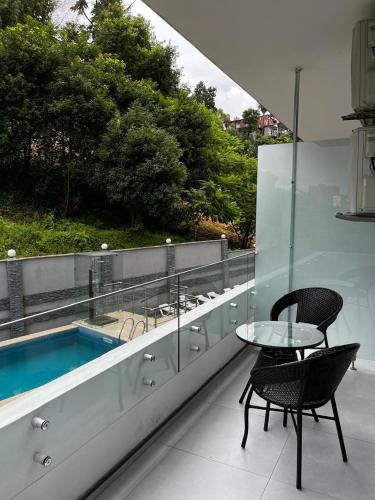a balcony with a table and chairs and a swimming pool at Green Line in Mtsvane Kontskhi