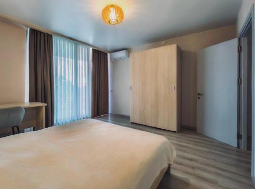a bedroom with a large bed and a wooden cabinet at Green Line in Mtsvane Kontskhi