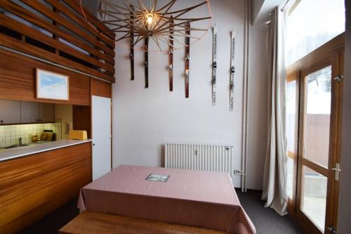une petite pièce avec une table et une cuisine dans l'établissement Résidence Le France - DUPLEX 6 PERS - LE FRANCE - PLAGNE CENTRE MAE-7221, à Aime La Plagne