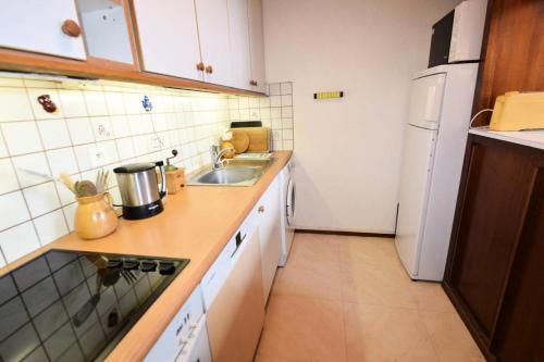 une petite cuisine avec un évier et un réfrigérateur dans l'établissement Résidence Le France - DUPLEX 6 PERS - LE FRANCE - PLAGNE CENTRE MAE-7221, à Aime La Plagne
