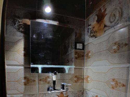 a bathroom with a mirror and a sink at Osiris Guest House in Abu Simbel