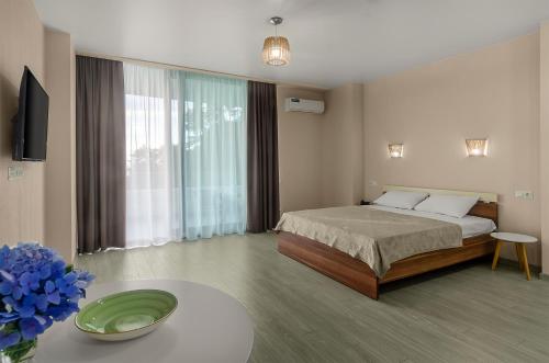 a bedroom with a bed and a table with a vase of flowers at Green Line in Mtsvane Kontskhi
