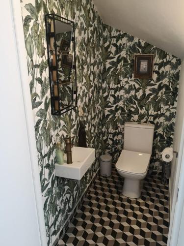 a bathroom with a toilet and a sink and a mirror at Hillside Villa in Mifol