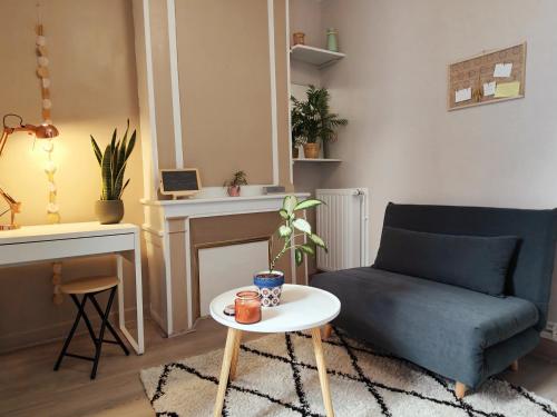 un salon avec un canapé bleu et une table dans l'établissement Le nid du prince, à Aurillac