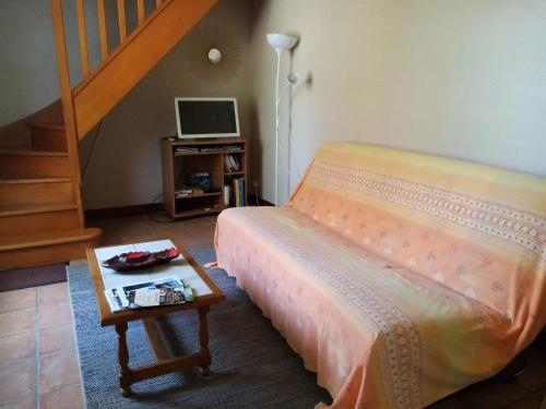 - une chambre avec un lit et une table avec une télévision dans l'établissement Maison charmante à Nadillac avec piscine privée, à Saint-Cernin