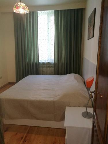 Un dormitorio con una cama grande con ventana. en Отличный отдых в центре Батуми, en Batumi