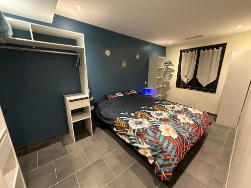 ein Schlafzimmer mit einem Bett und einer blauen Wand in der Unterkunft Maison Isle sur la sorgue in LʼIsle-sur-la-Sorgue