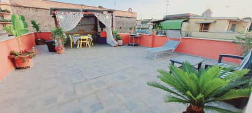 a patio with chairs and a table on a building at B&B JOY in Nettuno