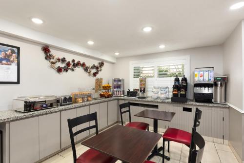 a kitchen with a table and chairs and a counter at Ramada by Wyndham Medford Airport North in Medford