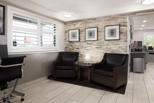 a barber shop with two chairs and a table in a room at Ramada by Wyndham Medford Airport North in Medford