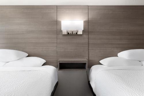 two beds sitting next to each other in a room at Ramada by Wyndham Medford Airport North in Medford