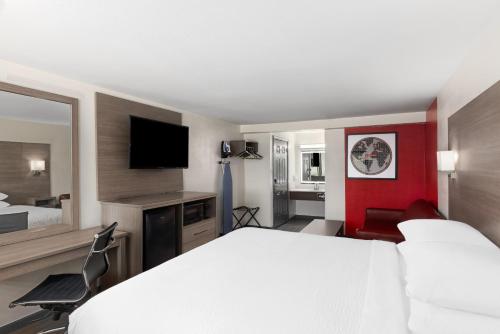 a hotel room with a large bed and a television at Ramada by Wyndham Medford Airport North in Medford