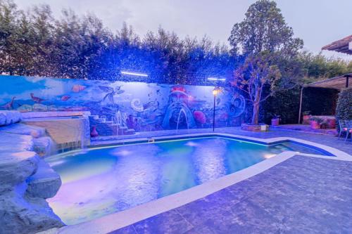 a swimming pool in a backyard with a mural at Hotel Casa Elemento Villa de Leyva in Villa de Leyva
