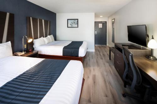 a hotel room with two beds and a flat screen tv at Hotel Mira Vista in El Cerrito
