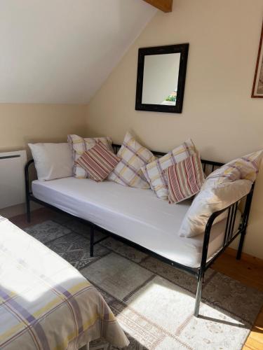 a couch with pillows on it in a room at Vue Du Vallon in Bersac-sur-Rivalier
