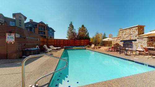 a large swimming pool in a yard with a patio at Snow Flower 204 -REDUCED RATES- Pool, Hot Tub, Balcony with Views, Steps to Gondolas, Restaurants in Steamboat Springs
