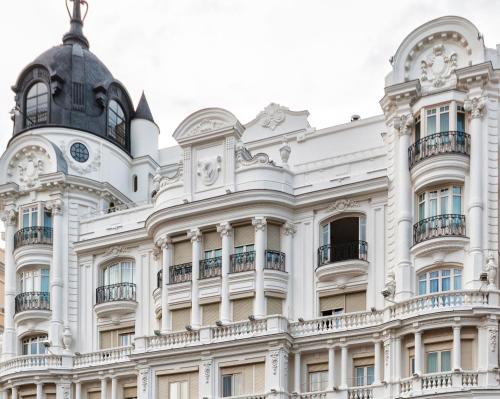 a white building with a clock on the top of it at Hotel Atlántico in Madrid