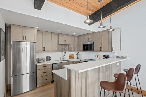 a kitchen with wooden cabinets and stainless steel appliances at Heated Pool and Hot Tub, Ski In, Ski Out, Top Level Unit, -Remodeled Fall 2022- in Steamboat Springs