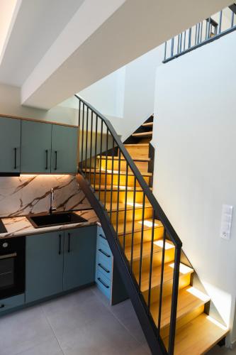 a staircase leading up to a kitchen with wooden stairs at Oktolia suites in Alexandroupoli