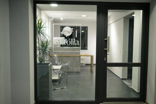 a glass door leading into a dining room with a table at Oktolia suites in Alexandroupoli