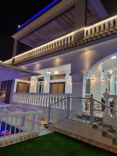 a balcony of a house at night with lights at Smart Chalet:سمارت شالية in Salalah