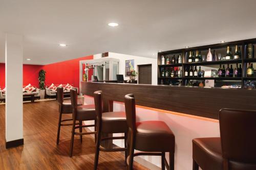 a bar in a restaurant with a bunch of chairs at Ramada Oxford in Waterstock