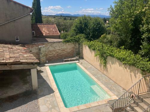 - une piscine dans une cour à côté d'un bâtiment dans l'établissement La Maison de Gabriel, à Villeuneuve-de-Berg