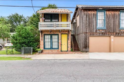 a house with a yellow door on a street at Downtown Scott Studio Near I-10, Walk to Dining in Scott
