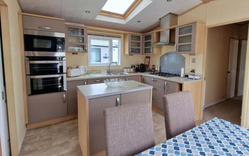 eine Küche mit Spüle und Herd oberen Backofen in der Unterkunft The Knightsbridge, Boulevard, Seal Bay Resort in Selsey