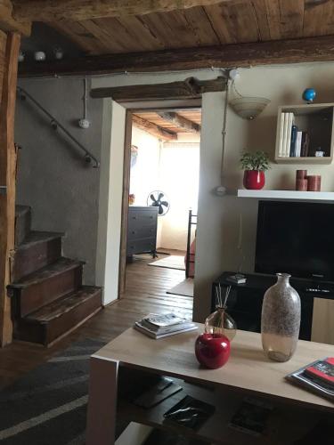 a living room with a table and a living room with stairs at CASA NONNA ELISA Stayerat a SEGUSINO Valdobbiadene in Segusino