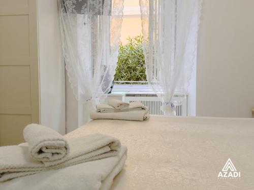 a bed with towels on it in front of a window at Azadi B&B Flaminio in Rome