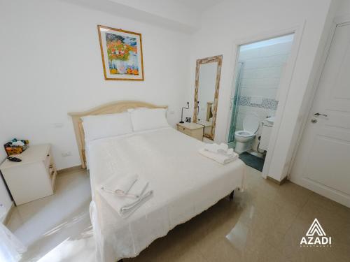 a bedroom with a white bed and a mirror at Azadi B&B Flaminio in Rome