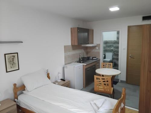 Un dormitorio con una cama y una pequeña cocina. en APARTMANSKI SMEŠTAJ SOLARIS kod Aqua Parka Studio Apartmani, en Soko Banja