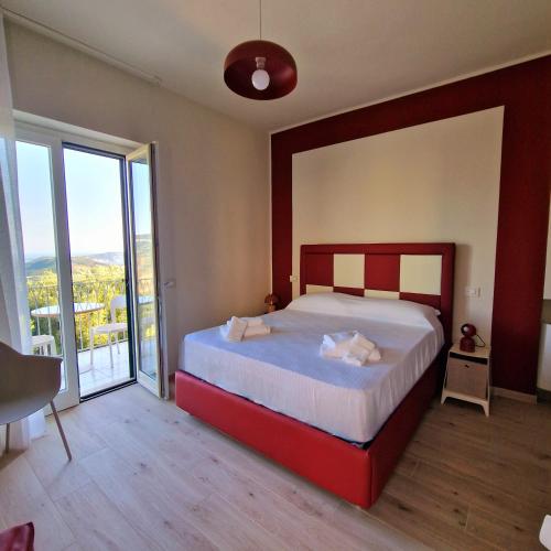 a bedroom with a large bed and a large window at marte rooms in Centola