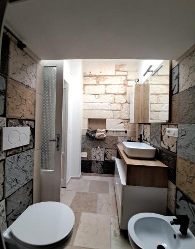 a bathroom with a white toilet and a sink at PETRAKIs HOUSE in Ostuni