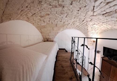 a bedroom with two beds in a stone room at PETRAKIs HOUSE in Ostuni