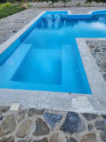 a swimming pool with blue water in a yard at Bella Villa room with large pool and close to beach in Las Galeras