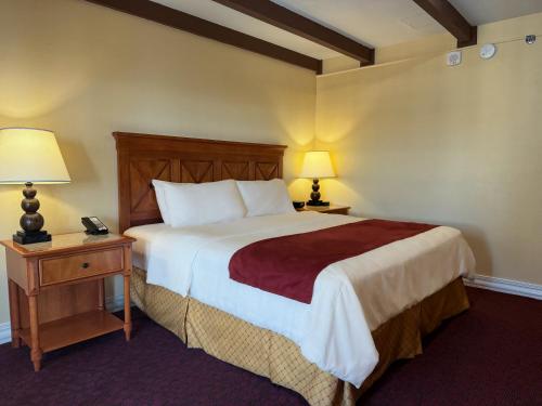 a bedroom with a large bed and two night stands with lamps at La Posada Hotel in Laredo