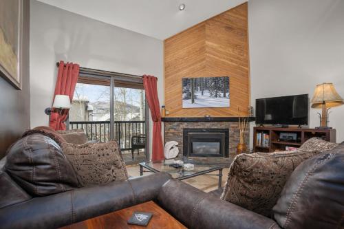 sala de estar con 2 sofás de cuero y chimenea en 3 Hot Tubs, Private Shuttle in Winter, Gas Fireplace, Free Bus, en Steamboat Springs