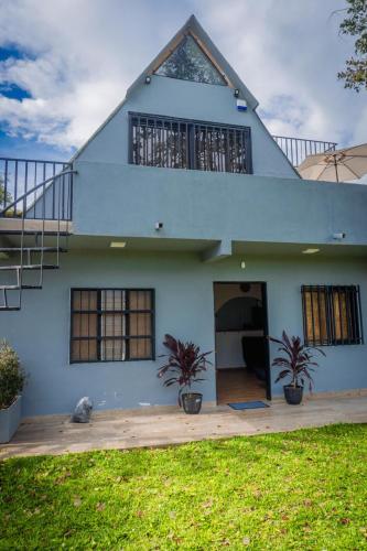 a white house with two plants in front of it at Cabaña333 in Guatapé