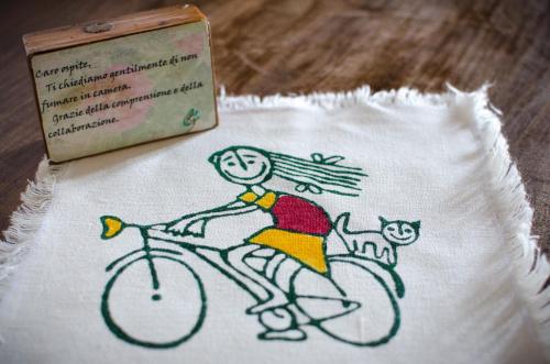a drawing of a person riding a bike with a cat at Agriturismo Ca'de'Gatti in Faenza